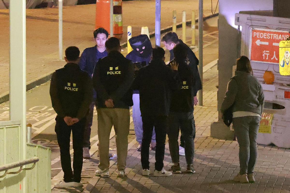 男疑犯被捕翌日後被黑布蒙頭押返現場重組案情。(資料圖片)