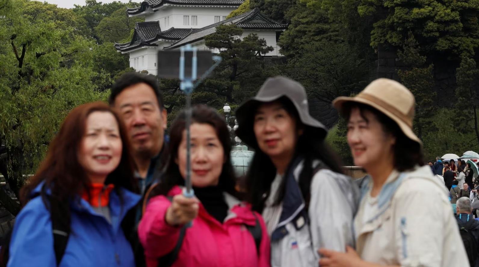 圖為一批中國遊客在東京皇居外自拍。(資料圖片)