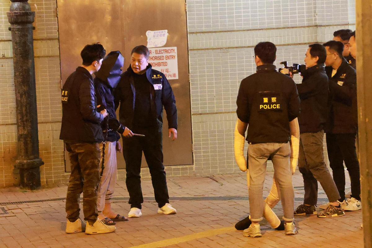 男疑犯被捕翌日後被黑布蒙頭押返現場重組案情。(資料圖片)