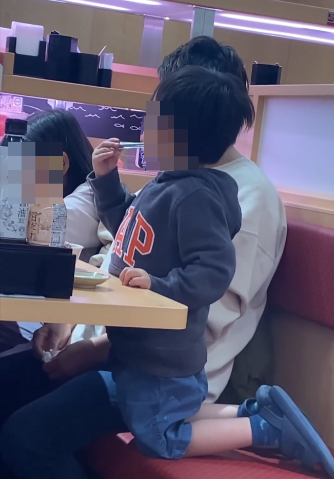 一名男童於沙田新城市進餐時被拍到多次舐夾薑的公用鉗,及後誤甩手將鉗掉到地面,身旁成年女子未有發現及介入男童行為。(Threads)