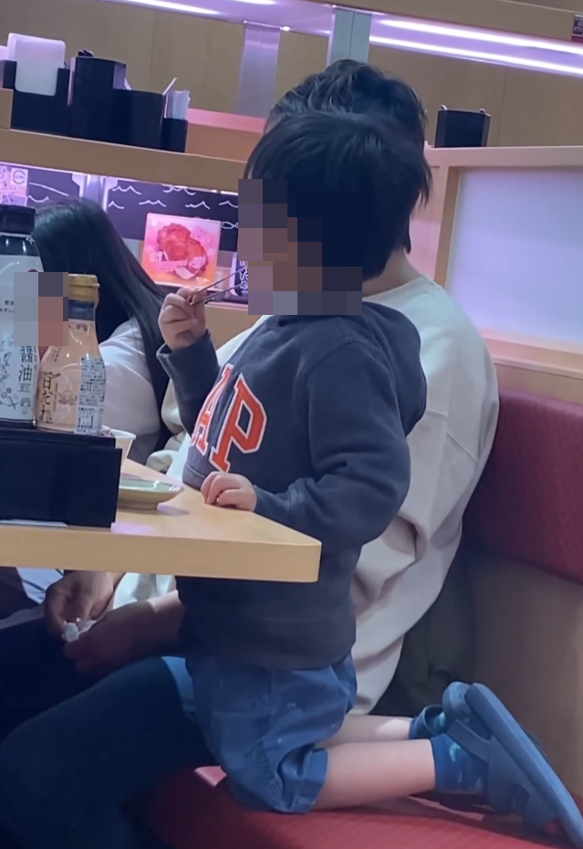 一名男童於沙田新城市進餐時被拍到多次舐夾薑的公用鉗,及後誤甩手將鉗掉到地面,身旁成年女子未有發現及介入男童行為。(Threads)