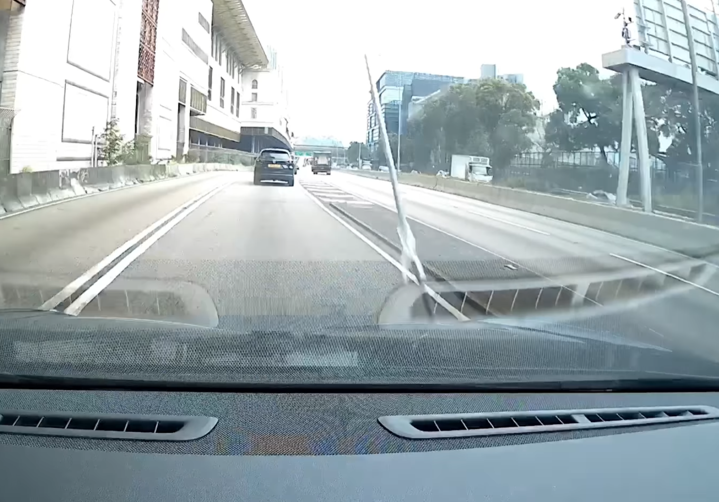 一支銀色條狀物垂直飛墮,「嘭」一聲擊中車頭位置,再彈上擋風玻璃。(facebook香港突發事故報料區影片截圖)