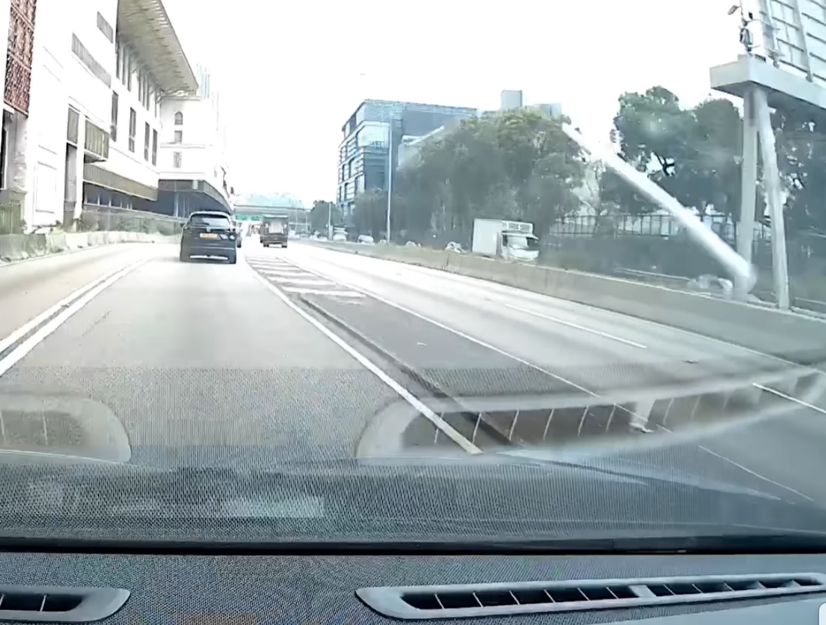 一支銀色條狀物垂直飛墮,「嘭」一聲擊中車頭位置,再彈上擋風玻璃。(facebook香港突發事故報料區影片截圖)