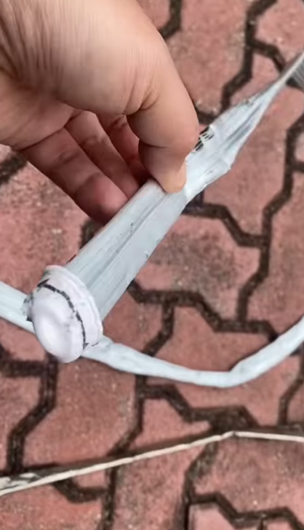 司機下車後展示3支扭曲變形的條狀物,近鏡所見為鋁條,私家車車頭冚及擋風玻璃有刮花損毀㾗迹。(facebook香港突發事故報料區影片截圖)