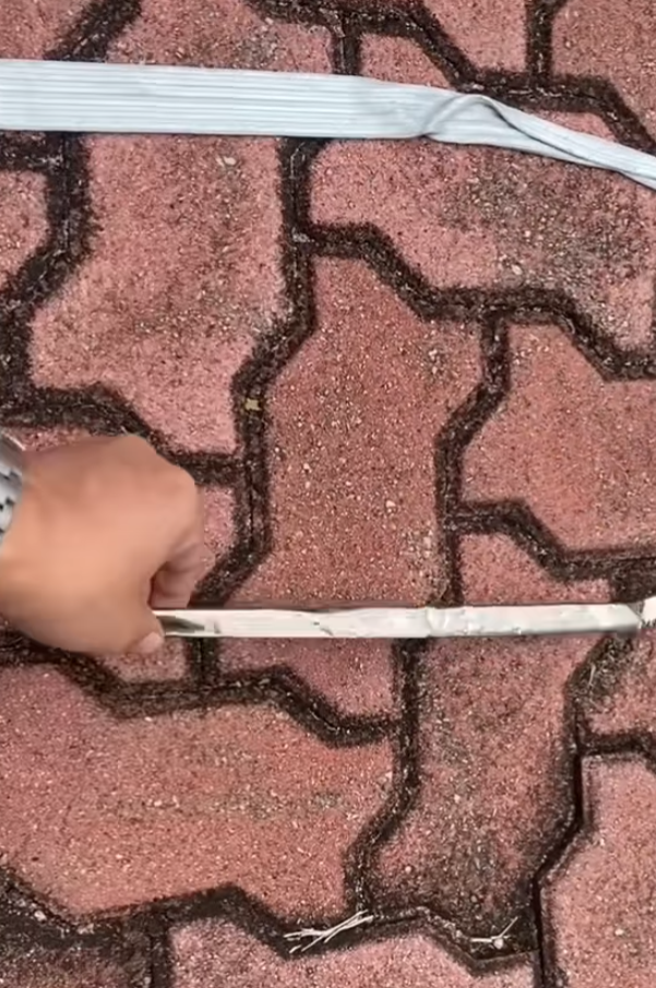 司機下車後展示3支扭曲變形的條狀物,近鏡所見為鋁條,私家車車頭冚及擋風玻璃有刮花損毀㾗迹。(facebook香港突發事故報料區影片截圖)