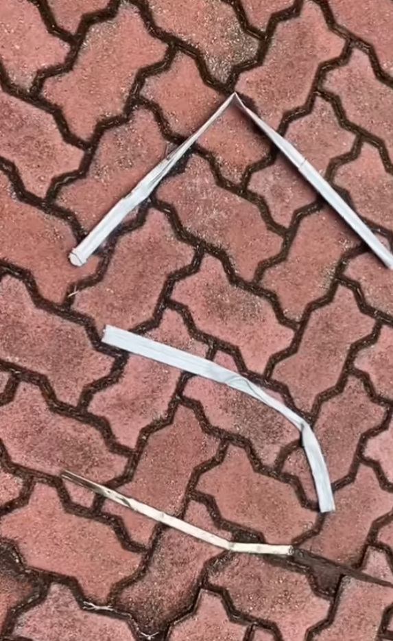 司機下車後展示3支扭曲變形的條狀物,近鏡所見為鋁條,私家車車頭冚及擋風玻璃有刮花損毀㾗迹。(facebook香港突發事故報料區影片截圖)