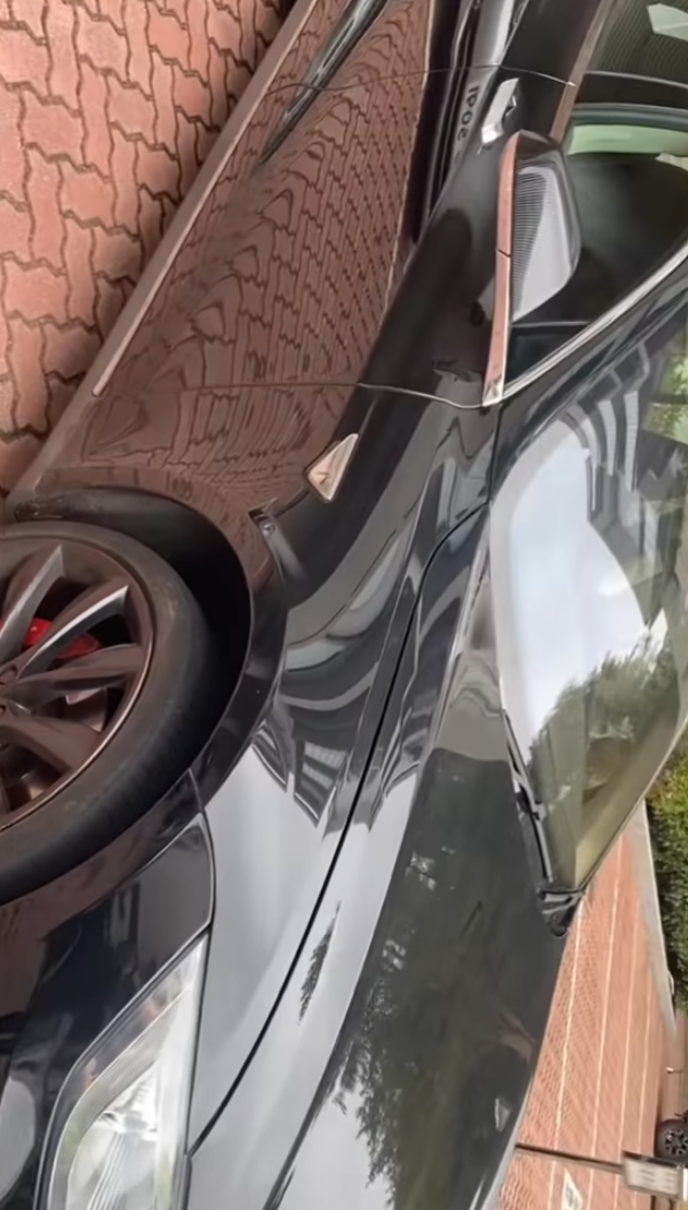 司機下車後展示3支扭曲變形的條狀物,近鏡所見為鋁條,私家車車頭冚及擋風玻璃有刮花損毀㾗迹。(facebook香港突發事故報料區影片截圖)