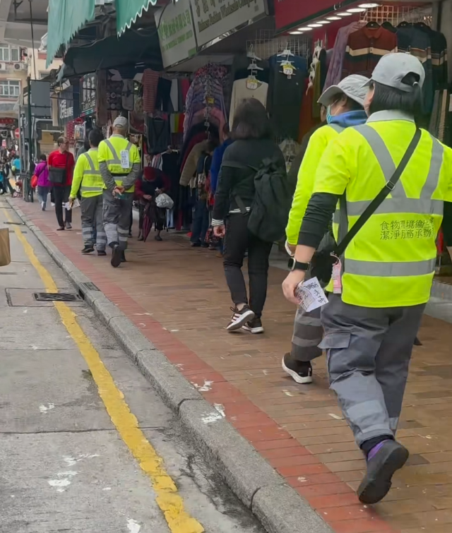 4名懷疑是食環署外判清潔工人,在深水埗工作時涉自編自導自演」,自攜及張貼街招拍攝留下工作證明後,再自行清拆相關街招。(Roni Wong fb影片截圖)