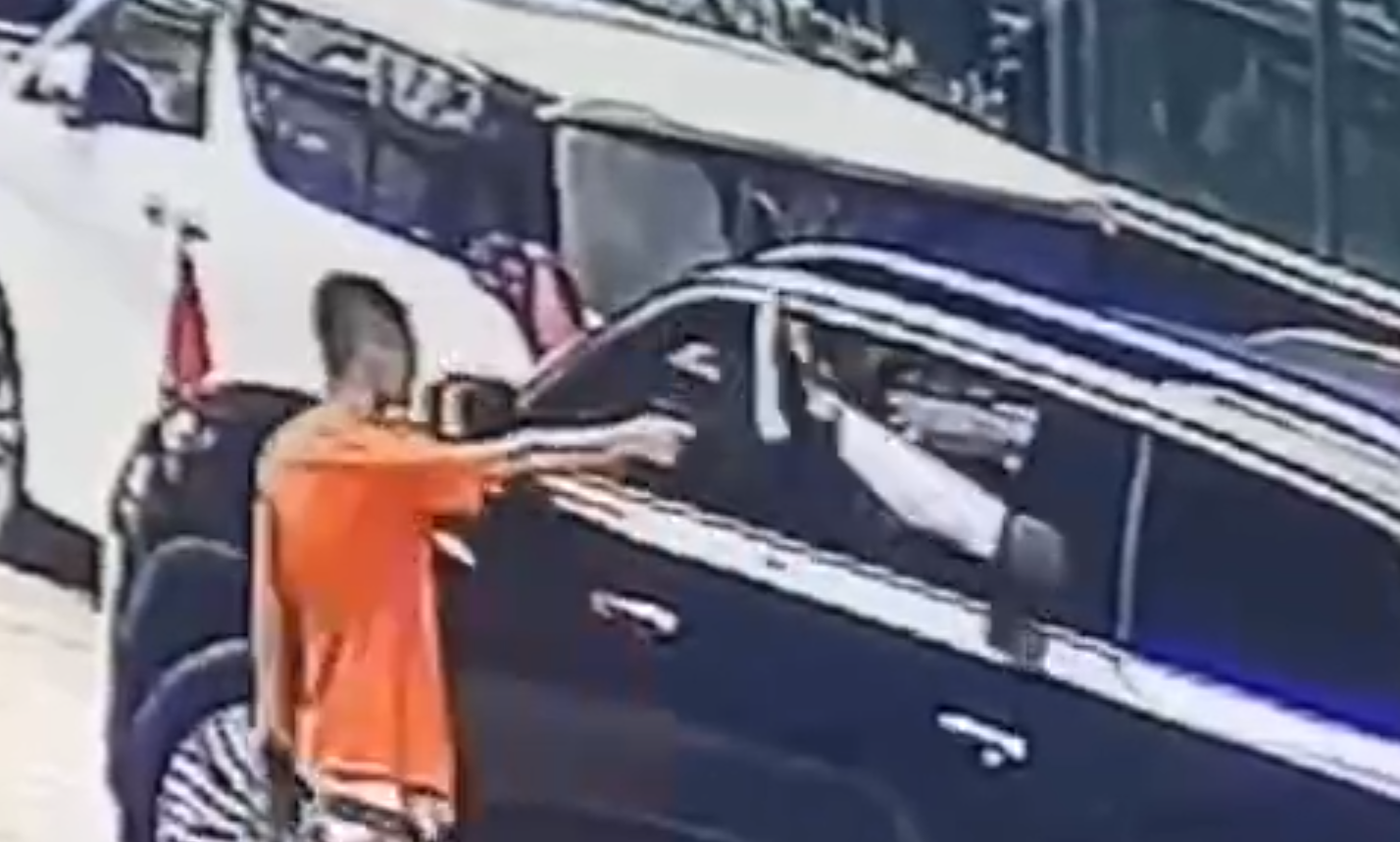 影片顯示,有兩名男子拿著兩支步槍跳下車衝進樓內,另有一名男子手持一把短槍對準一輛汽車的後座。(影片截圖)