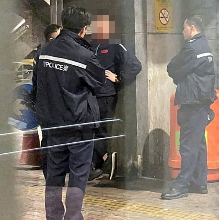 網絡流傳一張攝於沙田某巴士總站的照片,畫面中一名身穿疑似九巴制服的男子正接受警方調查,身旁站着一名身着空姐制服的女子。(網上圖片)