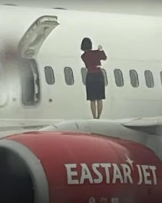 有多名女空服員打開逃生門後爬上機翼拍照,加上該機場是禁止攝影的軍用機場,相片曝光後引發爭議。(YouTube)