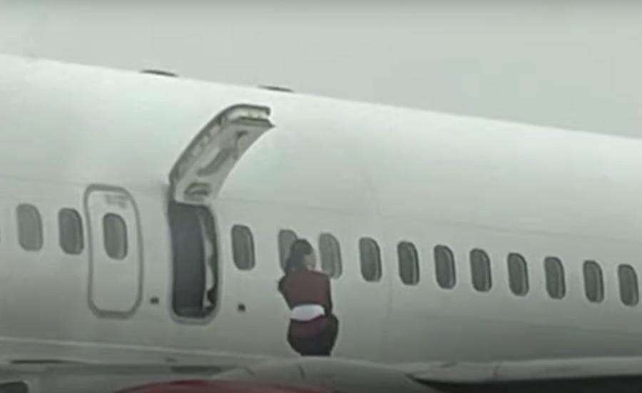 有多名女空服員打開逃生門後爬上機翼拍照,加上該機場是禁止攝影的軍用機場,相片曝光後引發爭議。(YouTube)
