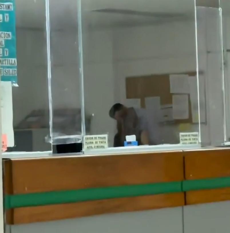 女職員坐在座位上,男職員則站在她面前彎腰與她熱吻。(X)