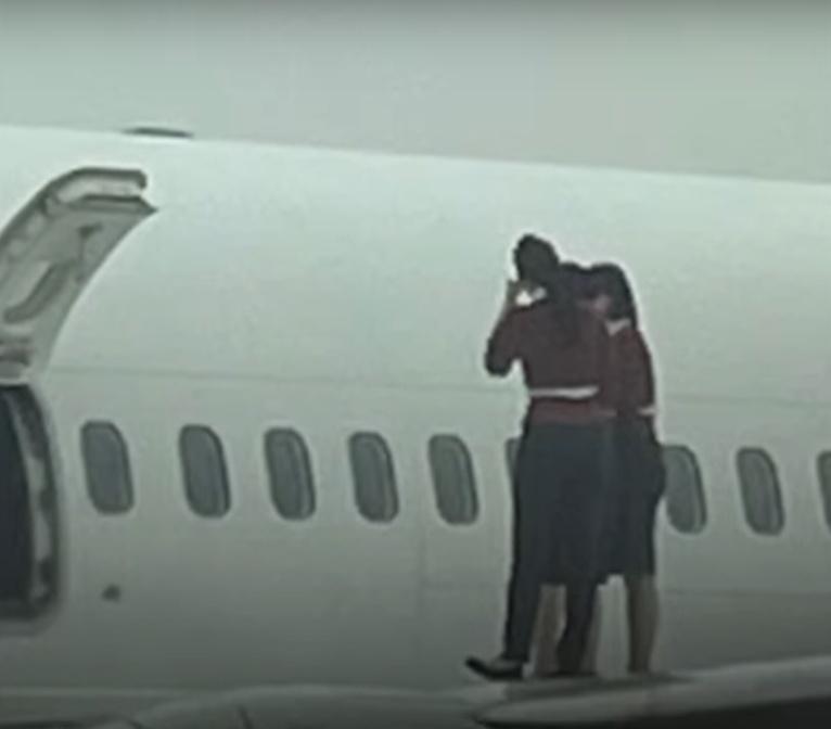 有多名女空服員打開逃生門後爬上機翼拍照,加上該機場是禁止攝影的軍用機場,相片曝光後引發爭議。(YouTube)