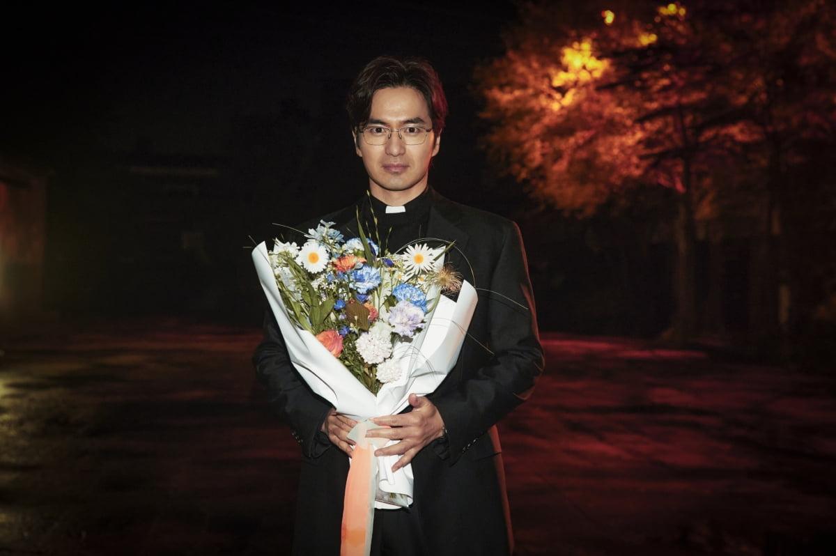 飾演保羅神父的李陣郁,手執鮮花拍照。