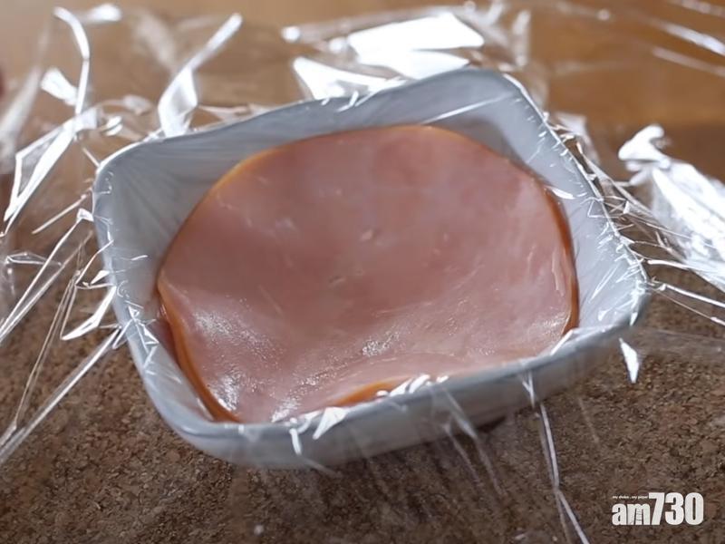 火腿雞蛋做法︰2.打蛋放在火腿上,把蛋黃戳幾個洞