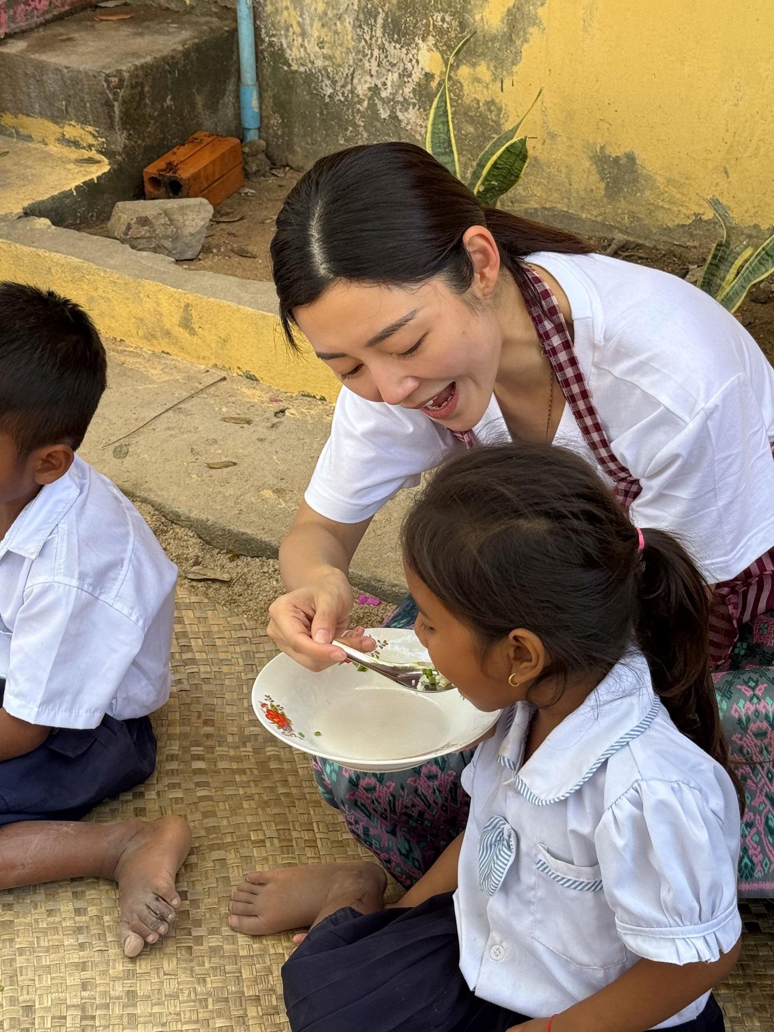 衛詩雅在幼稚園協助煮營養餐後,親自餵孩童進食。