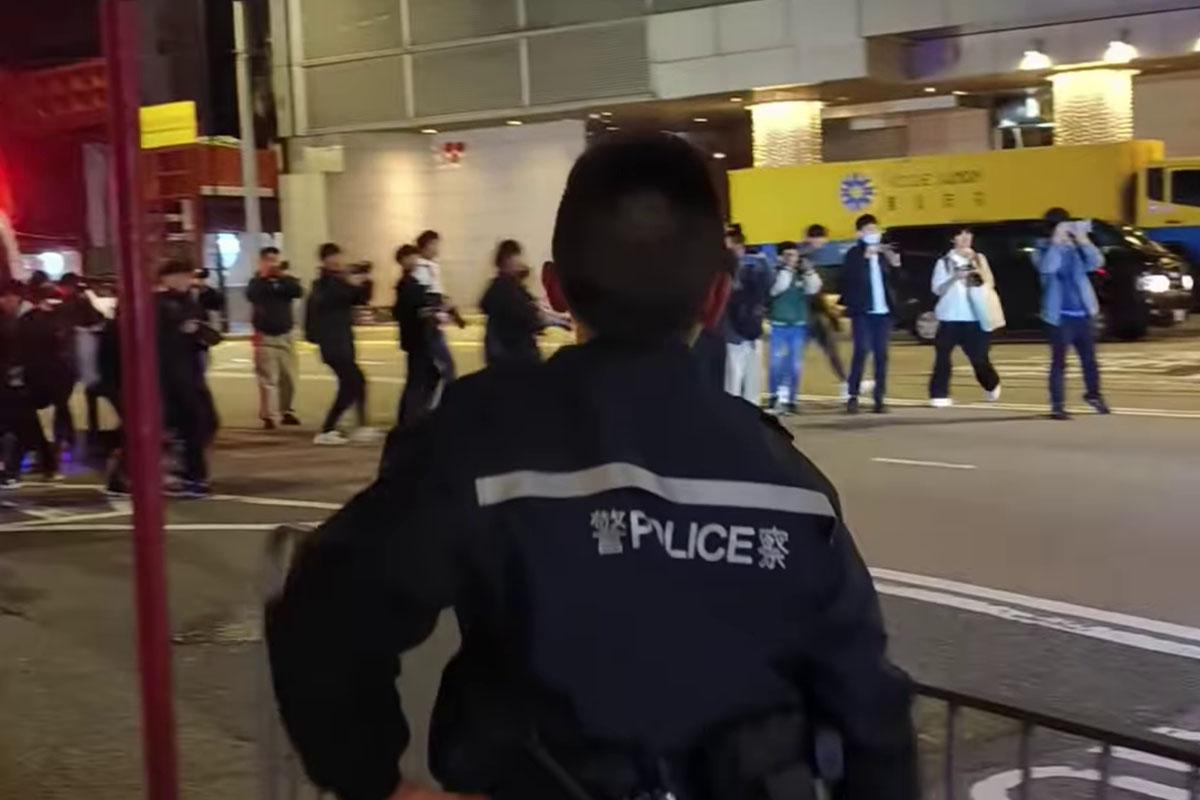 一批巴士迷凌晨站在禮頓道,準備拍攝渣打馬拉松特別路線,有警員見狀要求他們返回行人路。(網上影片截圖)