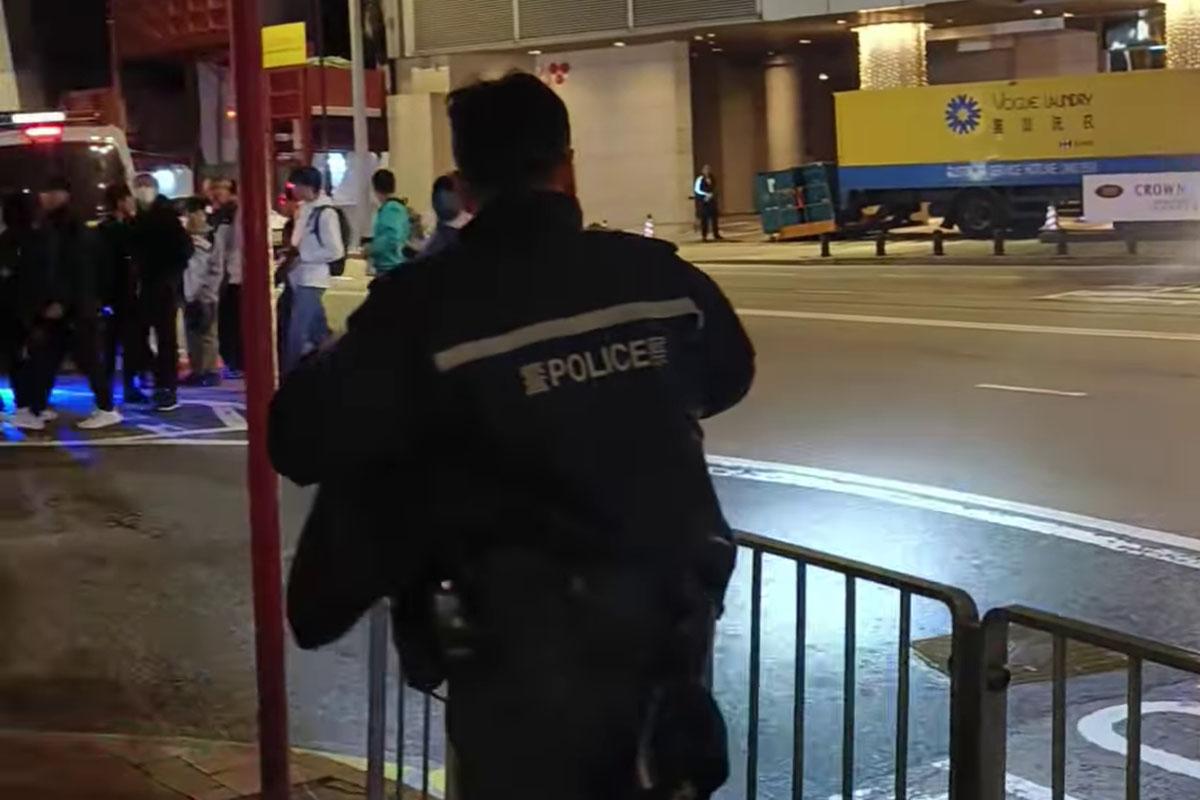 一批巴士迷凌晨站在禮頓道,準備拍攝渣打馬拉松特別路線,有警員見狀要求他們返回行人路。(網上影片截圖)