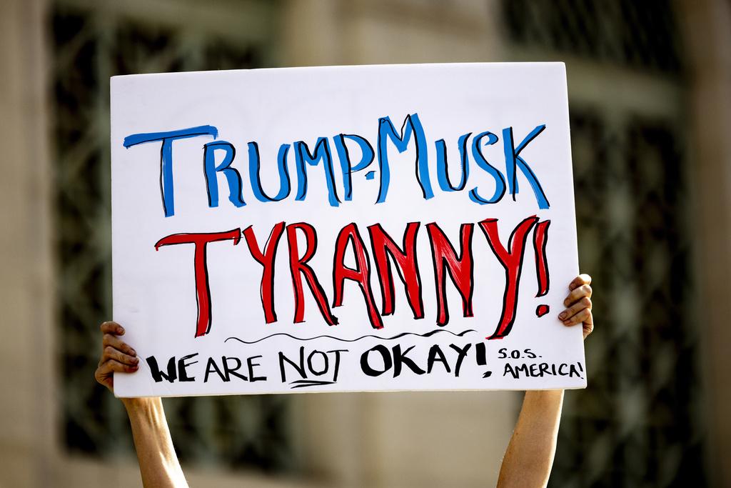 周一是「總統日」,洛杉磯有民眾示威,有人批評特朗普及馬斯克獨裁。(美聯社)