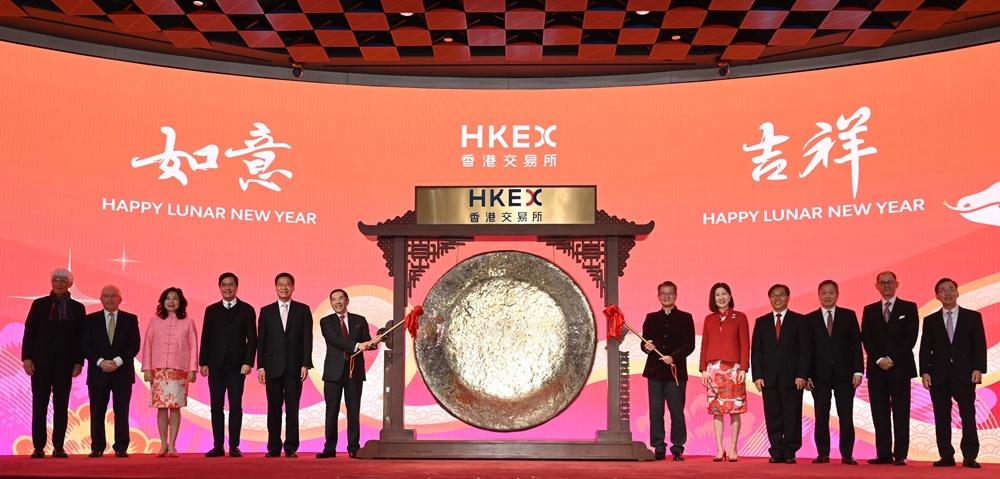 陳茂波(右六)和港交所主席唐家成(左六)主持敲鑼儀式。(政府新聞處圖)