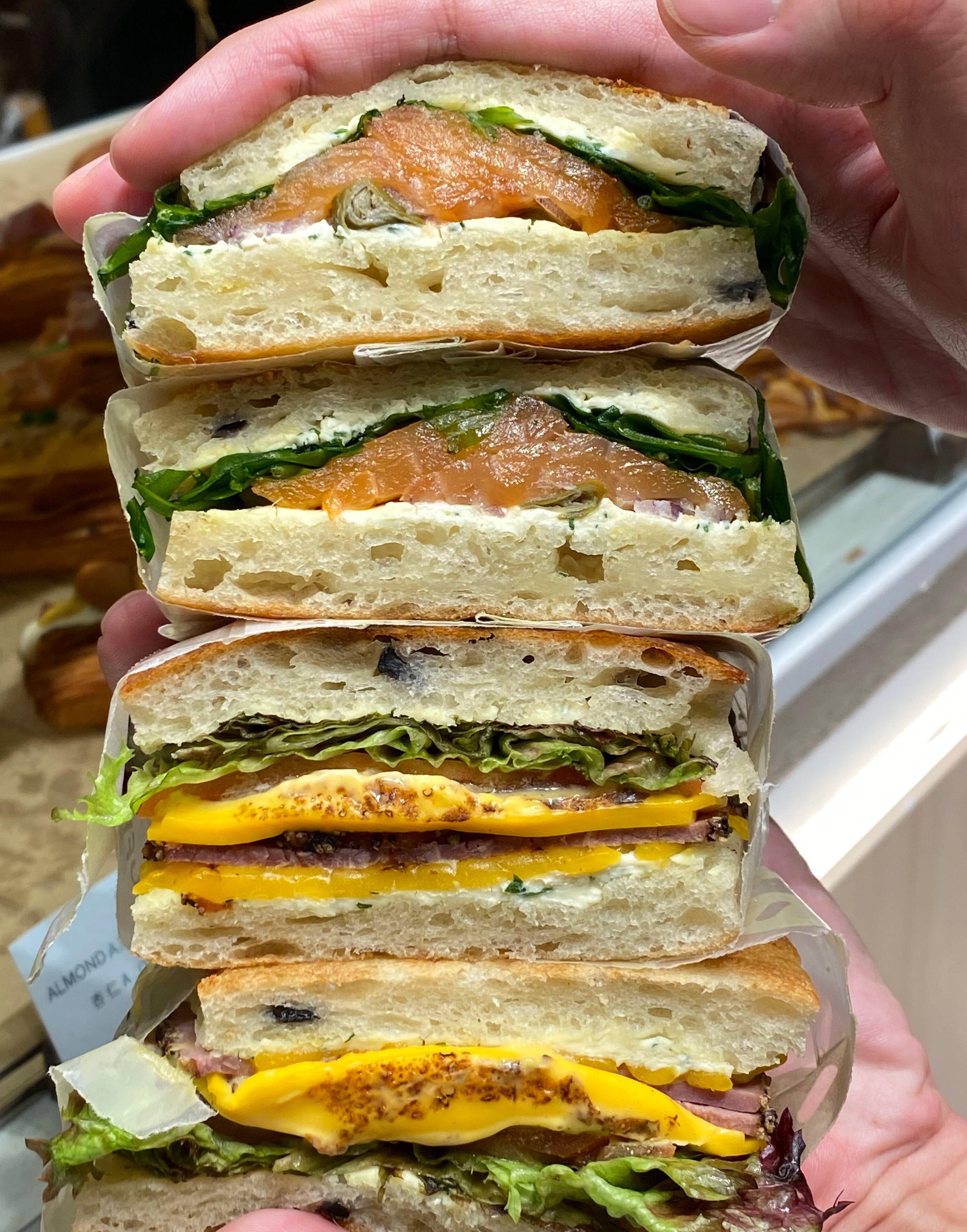 Focaccia三文治系列$45 用法國麵粉搓製麵糰,加入薯仔粒可長時間保持濕潤鬆軟,並加入橄欖及芝士帶出鹹香,分別配搭火雞火腿芝士、烤牛肉、煙燻三文魚製作三文治。