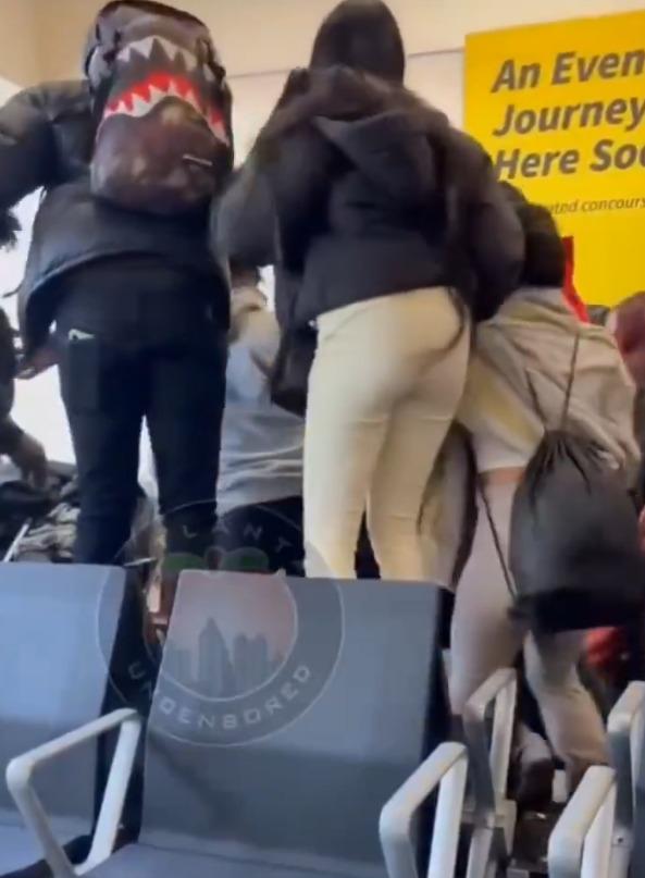 美國機場候機室出現MMA,部份人站在椅子上。(影片截圖)