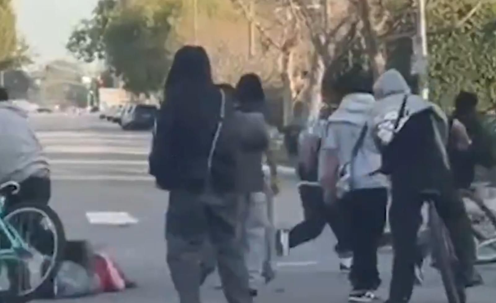 單車少年「往死裡打」落車理論的司機(紅衫)。(影片截圖)