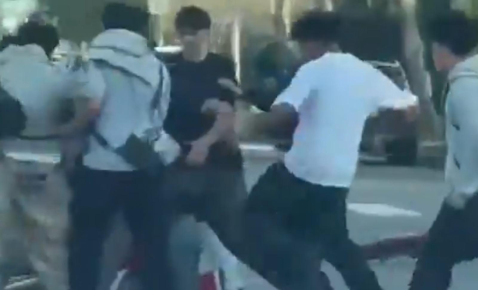 洛杉磯司機因汽車被撞落車理論 竟被廿名單車少年圍毆。(影片截圖)