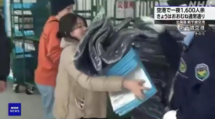 機場人員向旅客派發毛毯和墊子等用品。(互聯網)