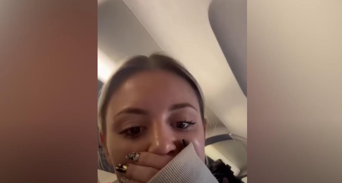 女乘客掩著口鼻,似乎在機艙裡聞到煙味。(互聯網)