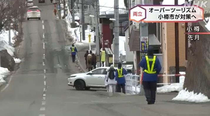 北海道小樽市街上有穿螢光背心的保安員巡邏,防止遊客衝出馬路拍攝。(互聯網)