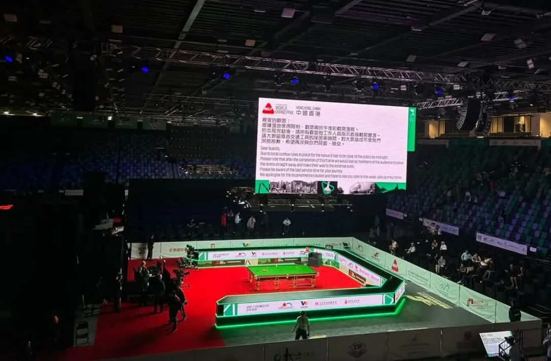 世界桌球大獎賽香港站在啟德體藝館舉行,不過早前的首日賽事「未完場就趕觀眾走」引爆風波,根據現場屏幕的訊息,中、英文版本通告略有不同,英文版用上「local curfew rules(本地宵禁規例)」的字眼,而中文版則解釋為「場地使用限制」。(網上圖片)