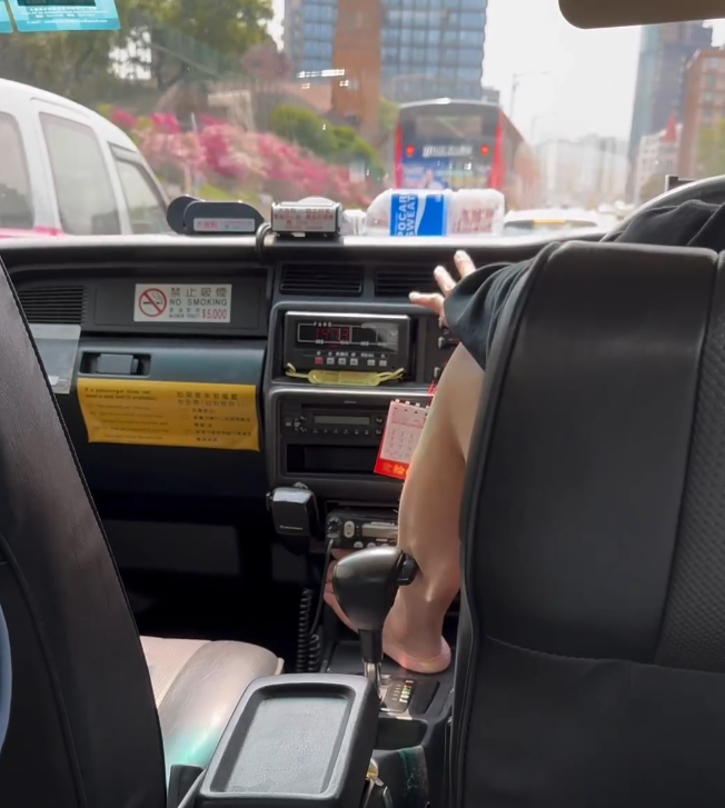 發帖網民上傳一段20秒短片,可見的士在窩打老道近瑪利諾修院學校向尖沙咀行駛,片中身穿黑衣的士司機赤着左腳,棟高放在波棍前方的空位,他並無雙手握緊軚盤,左手放在左腳膝上,狀似輕鬆。(Threads)