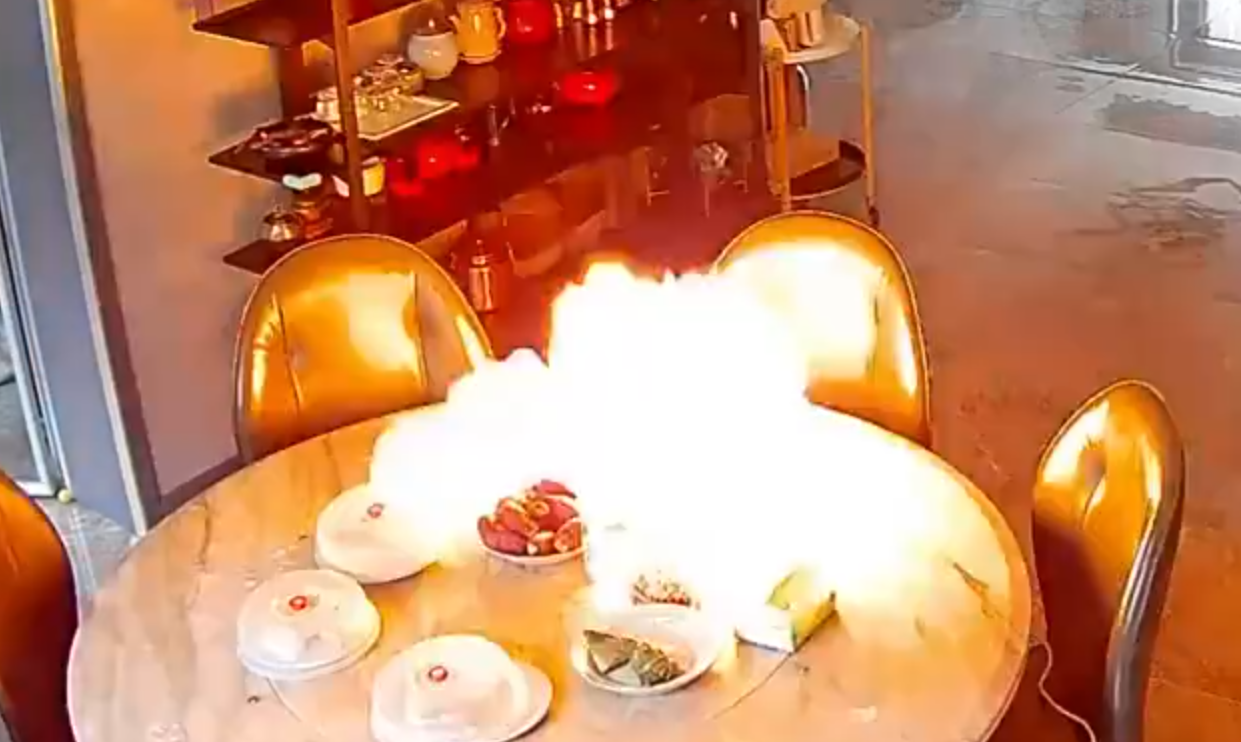 事發在河北唐山一戶人家,閉路鏡頭可見於上周六(15日)早上10時許,已準備餸菜的電動餐枱突然爆炸起火,火光四射,「連桌帶餸」一齊燃燒。事發時屋內兩名女子慌亂中不會用滅火器,最終以防火布撲滅火焰。(影片截圖)