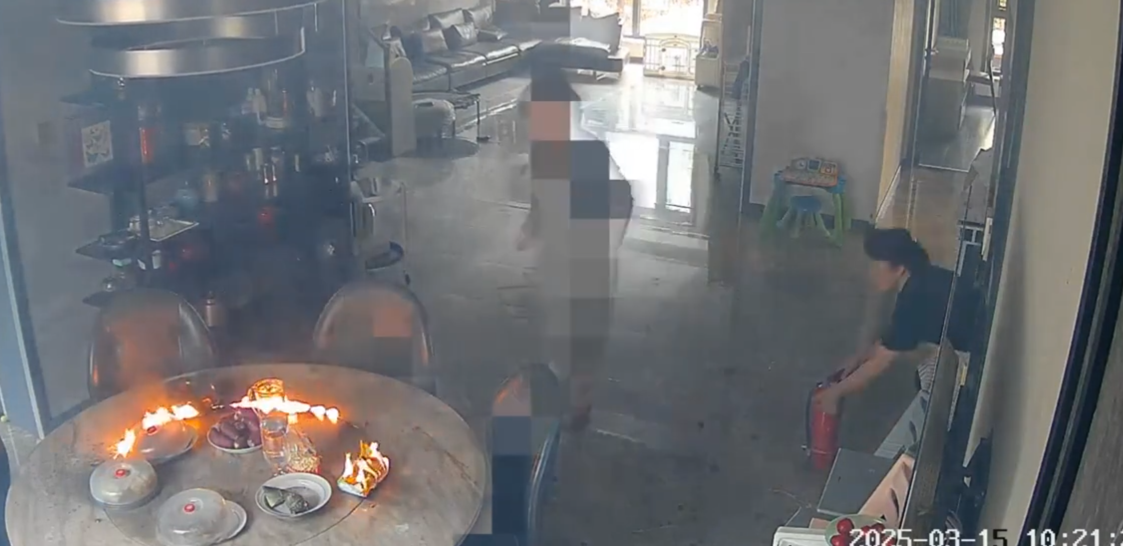 事發在河北唐山一戶人家,閉路鏡頭可見於上周六(15日)早上10時許,已準備餸菜的電動餐枱突然爆炸起火,火光四射,「連桌帶餸」一齊燃燒。事發時屋內兩名女子慌亂中不會用滅火器,最終以防火布撲滅火焰。(影片截圖)