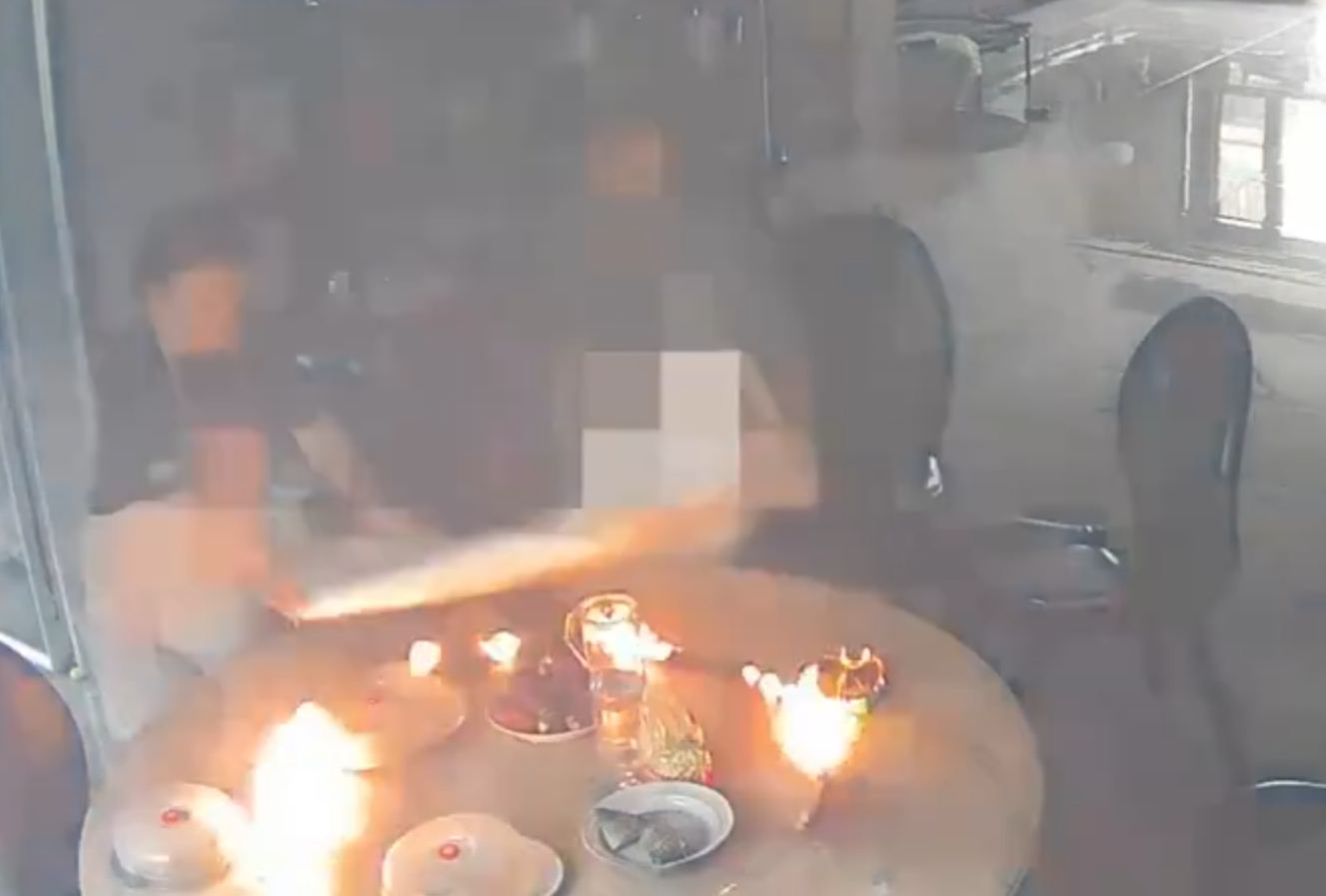 事發在河北唐山一戶人家,閉路鏡頭可見於上周六(15日)早上10時許,已準備餸菜的電動餐枱突然爆炸起火,火光四射,「連桌帶餸」一齊燃燒。事發時屋內兩名女子慌亂中不會用滅火器,最終以防火布撲滅火焰。(影片截圖)
