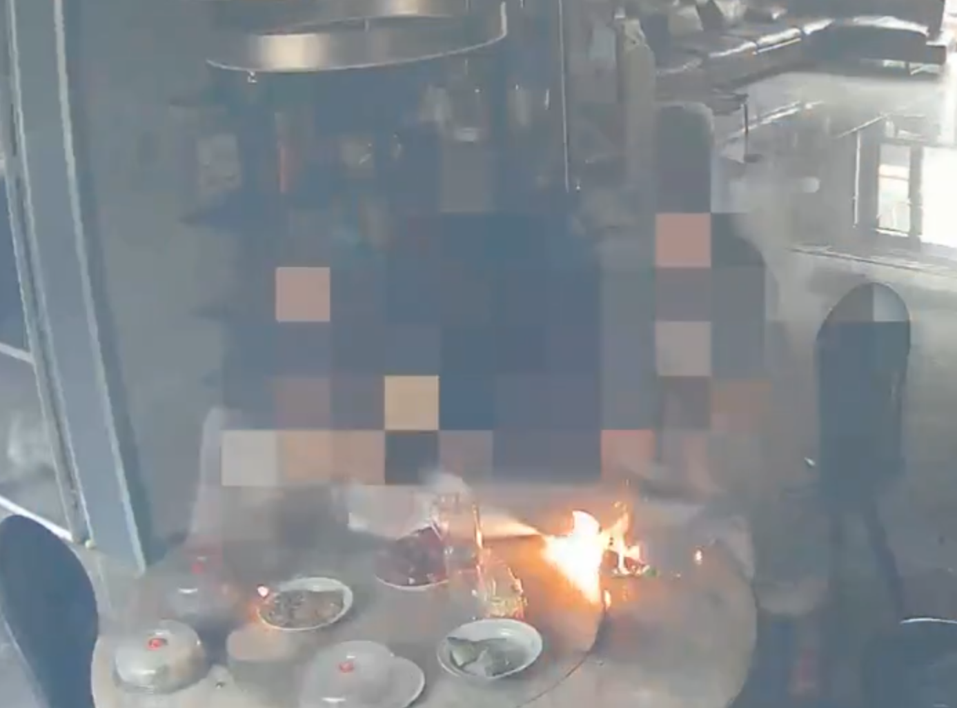 事發在河北唐山一戶人家,閉路鏡頭可見於上周六(15日)早上10時許,已準備餸菜的電動餐枱突然爆炸起火,火光四射,「連桌帶餸」一齊燃燒。事發時屋內兩名女子慌亂中不會用滅火器,最終以防火布撲滅火焰。(影片截圖)