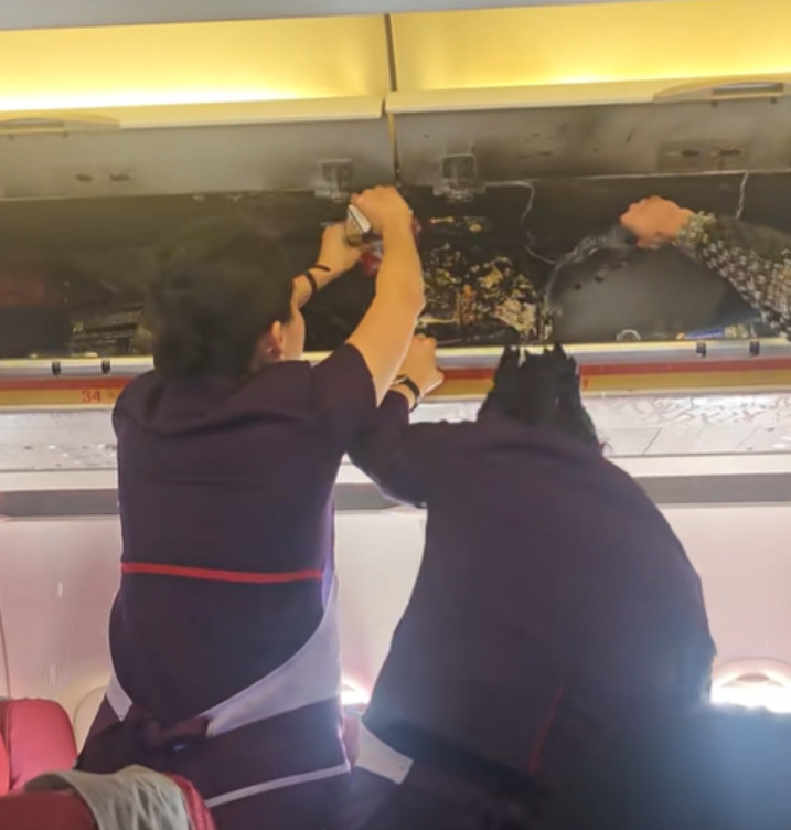 香港航空HX115原定杭州回港,中途轉飛福州。附近多個座位的乘客急疏散,及後客艙行李架火勢已撲滅,可見有燃燒痕跡,空姐及乘客不停倒蘋果汁及樽裝水降溫,不斷有水從行李架流出。(影片截圖)