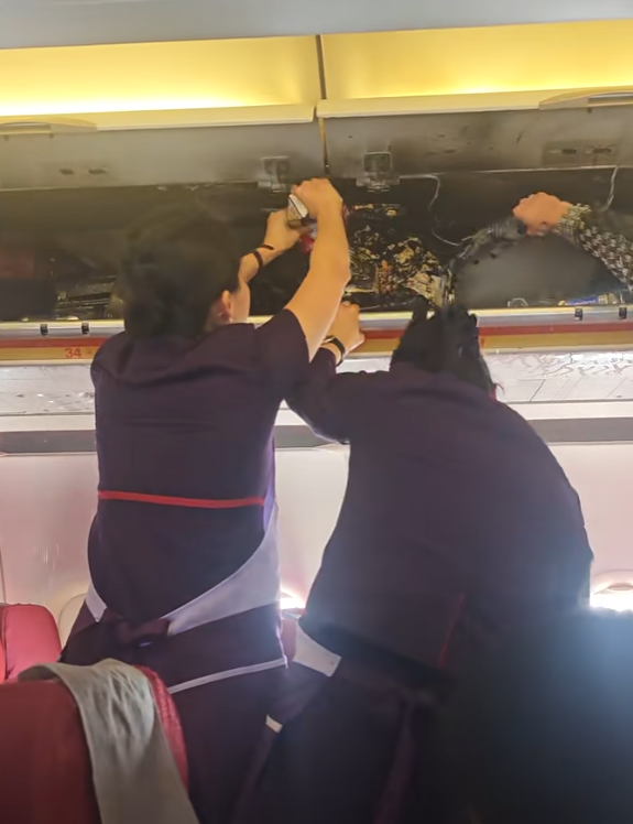 香港航空HX115原定杭州回港,中途轉飛福州。附近多個座位的乘客急疏散,及後客艙行李架火勢已撲滅,可見有燃燒痕跡,空姐及乘客不停倒蘋果汁及樽裝水降溫,不斷有水從行李架流出。(影片截圖)