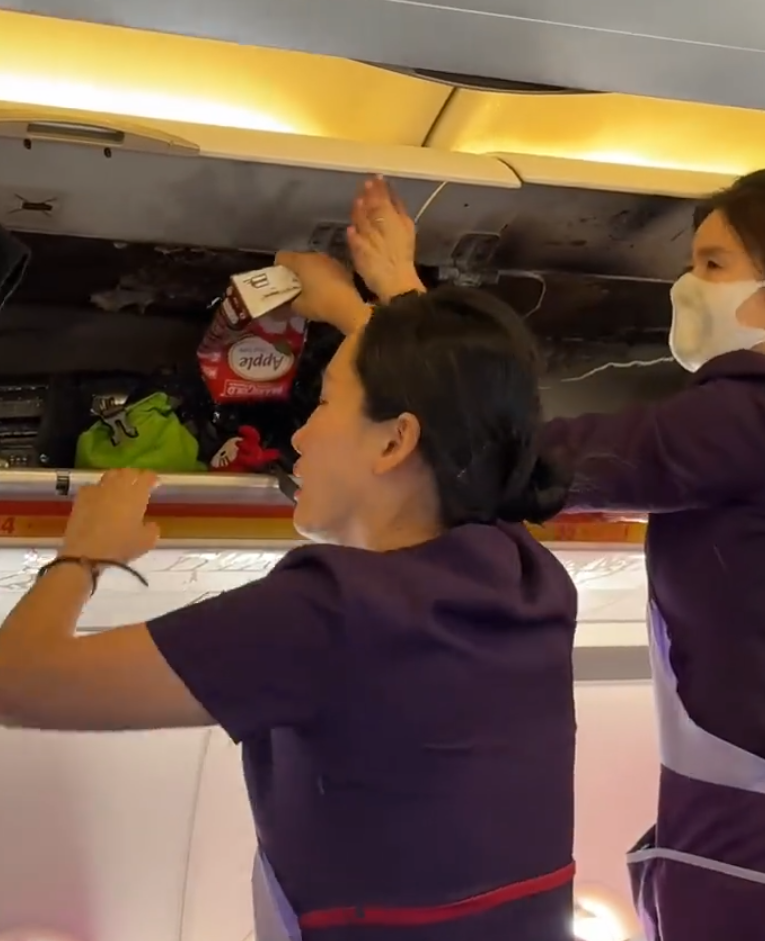 香港航空HX115原定杭州回港,中途轉飛福州。附近多個座位的乘客急疏散,及後客艙行李架火勢已撲滅,可見有燃燒痕跡,空姐及乘客不停倒蘋果汁及樽裝水降溫,不斷有水從行李架流出。(影片截圖)