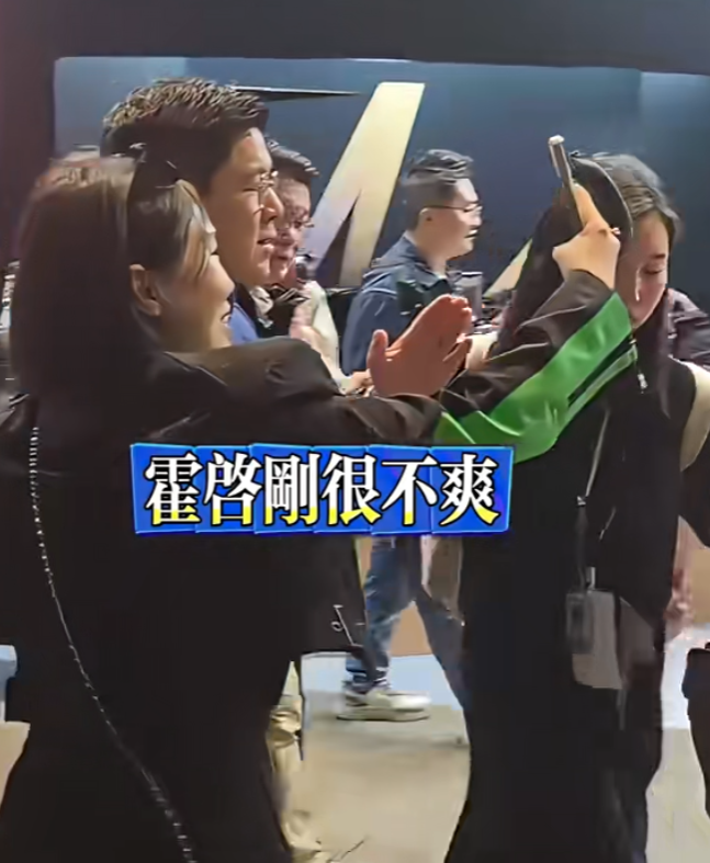 霍啟剛遇到多名人士死纏強行自拍阻擋去路,行為過火,令霍啟剛罕有一度黑面,向對方解釋之後仍不得不合影。(影片截圖)