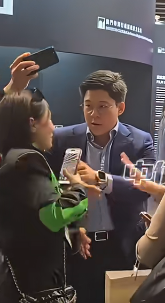 霍啟剛遇到多名人士死纏強行自拍阻擋去路,行為過火,令霍啟剛罕有一度黑面,向對方解釋之後仍不得不合影。(影片截圖)