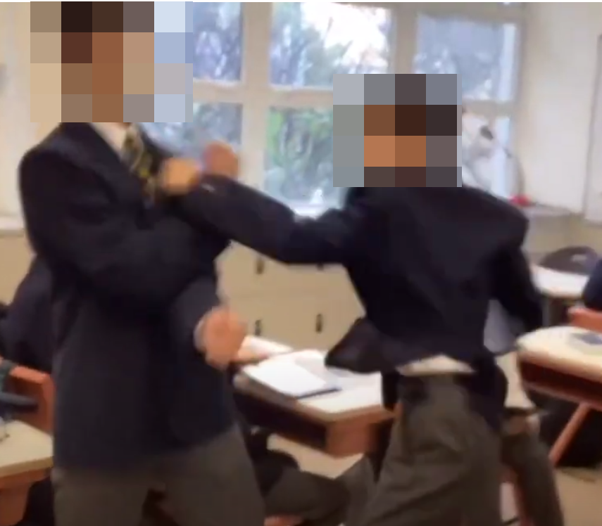 網上近日流傳影片,顯示有兩名男學生在課室內打架,有人被拳打頭部推倒在地後再用腳踩,躺在地上哭泣。根據校服和窗外環境,疑是中西區名校聖保羅書院。(影片截圖)