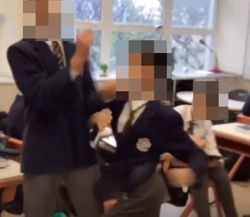 網上近日流傳影片,顯示有兩名男學生在課室內打架,有人被拳打頭部推倒在地後再用腳踩,躺在地上哭泣。根據校服和窗外環境,疑是中西區名校聖保羅書院。(影片截圖)