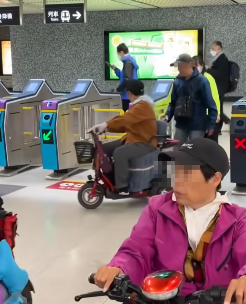 網上瘋傳一段有多名乘客坐電動三輪車的代步車上,出閘離開港鐵會展站收費區範圍的影片。(影片截圖)