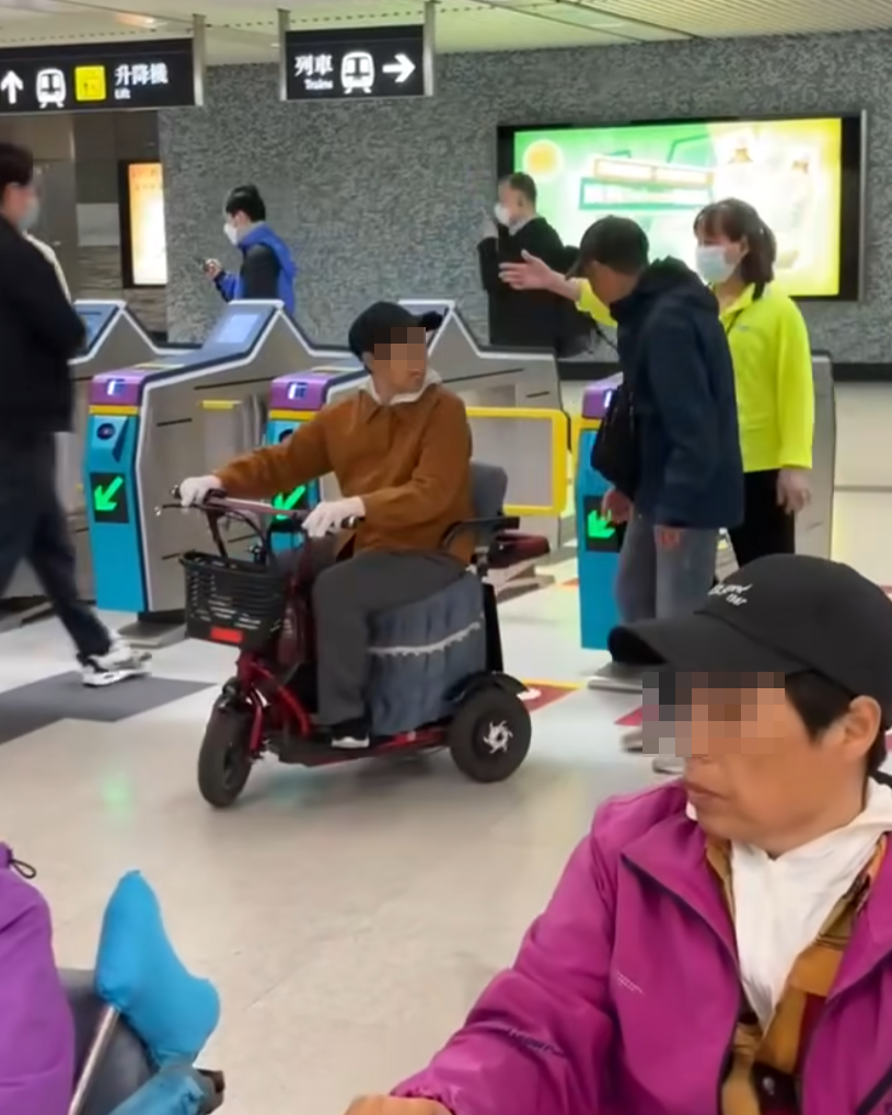 網上瘋傳一段有多名乘客坐電動三輪車的代步車上,出閘離開港鐵會展站收費區範圍的影片。(影片截圖)