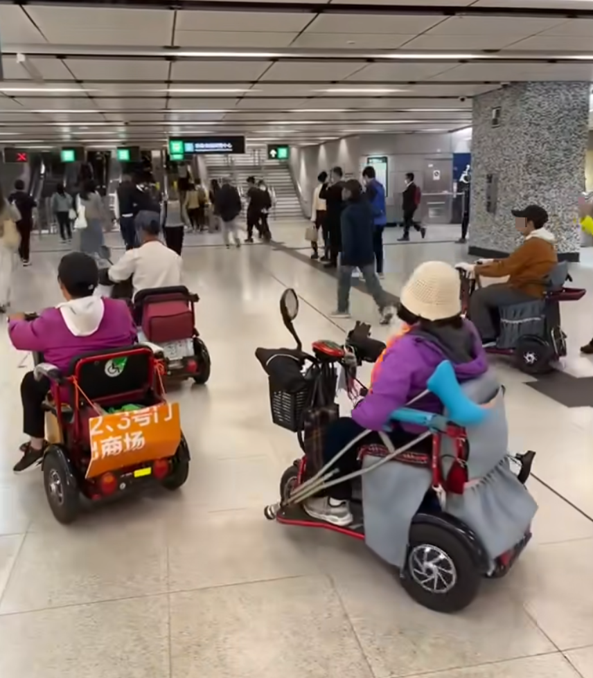 網上瘋傳一段有多名乘客坐電動三輪車的代步車上,出閘離開港鐵會展站收費區範圍的影片。(影片截圖)