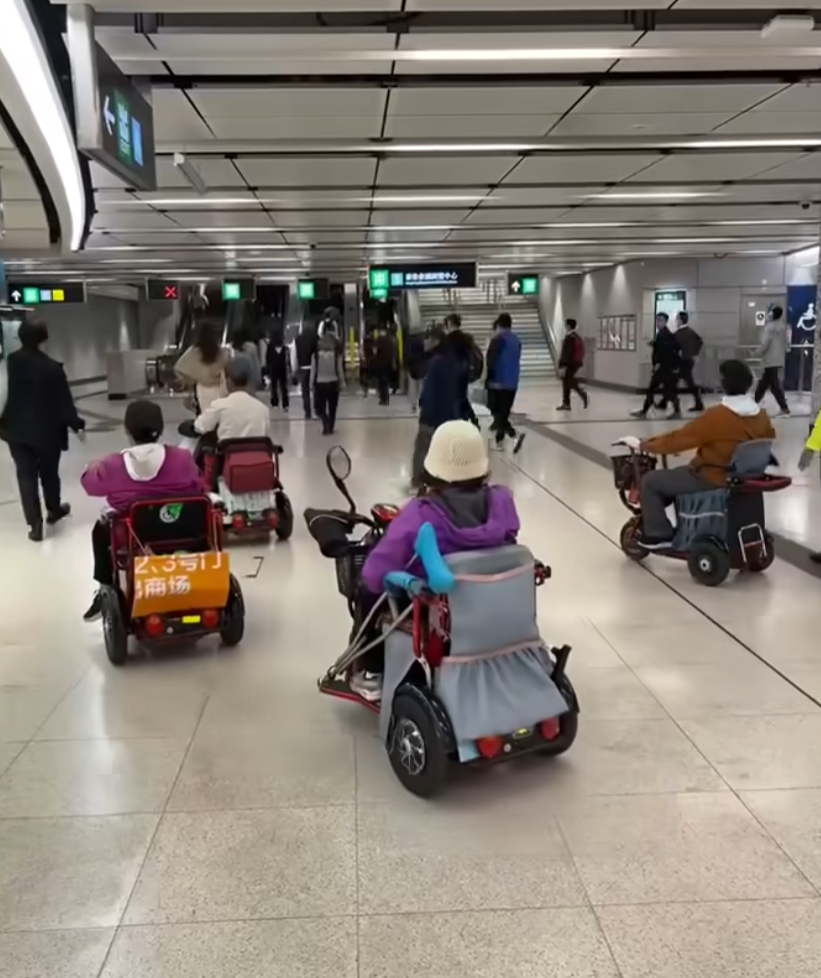 網上瘋傳一段有多名乘客坐電動三輪車的代步車上,出閘離開港鐵會展站收費區範圍的影片。(影片截圖)