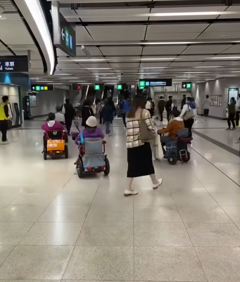 網上瘋傳一段有多名乘客坐電動三輪車的代步車上,出閘離開港鐵會展站收費區範圍的影片。(影片截圖)